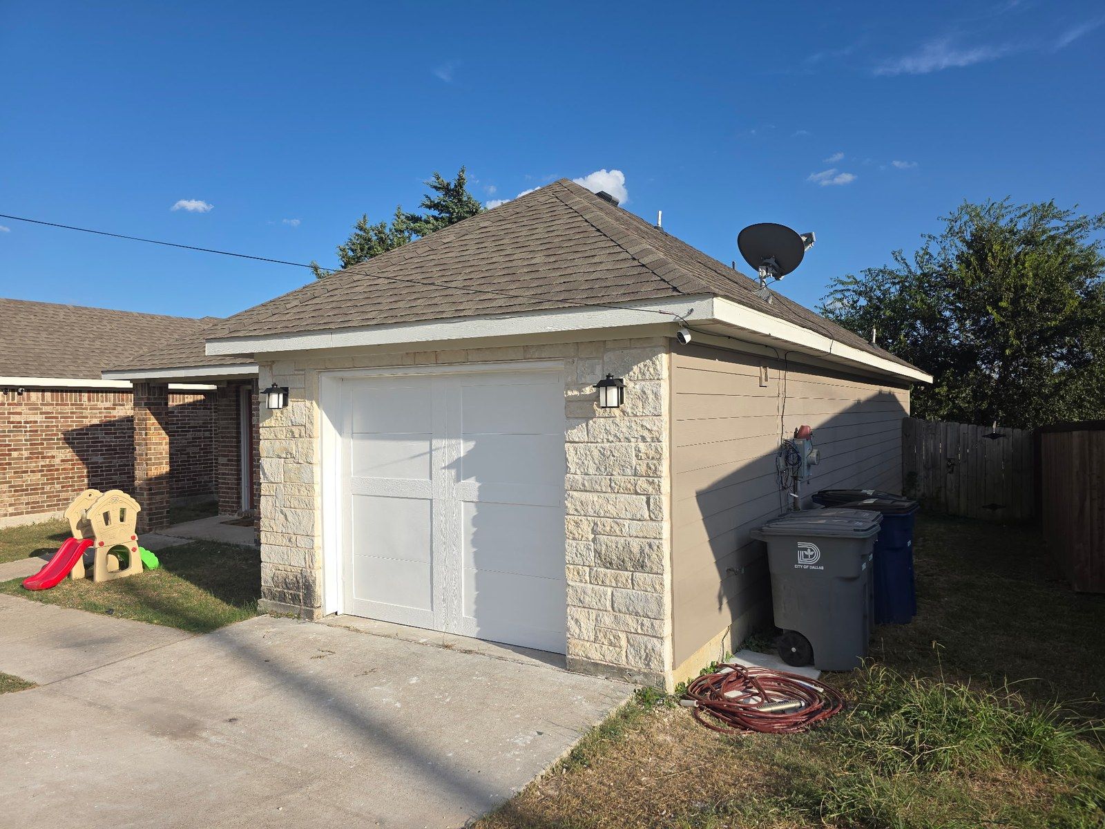 Same garage rebuilt, with the stone, siding and a new garage door restored