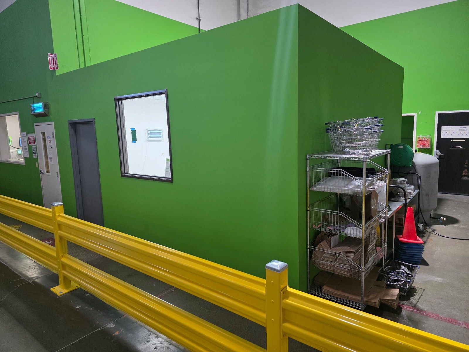 Finished warehouse office box painted green, with a yellow safety rail