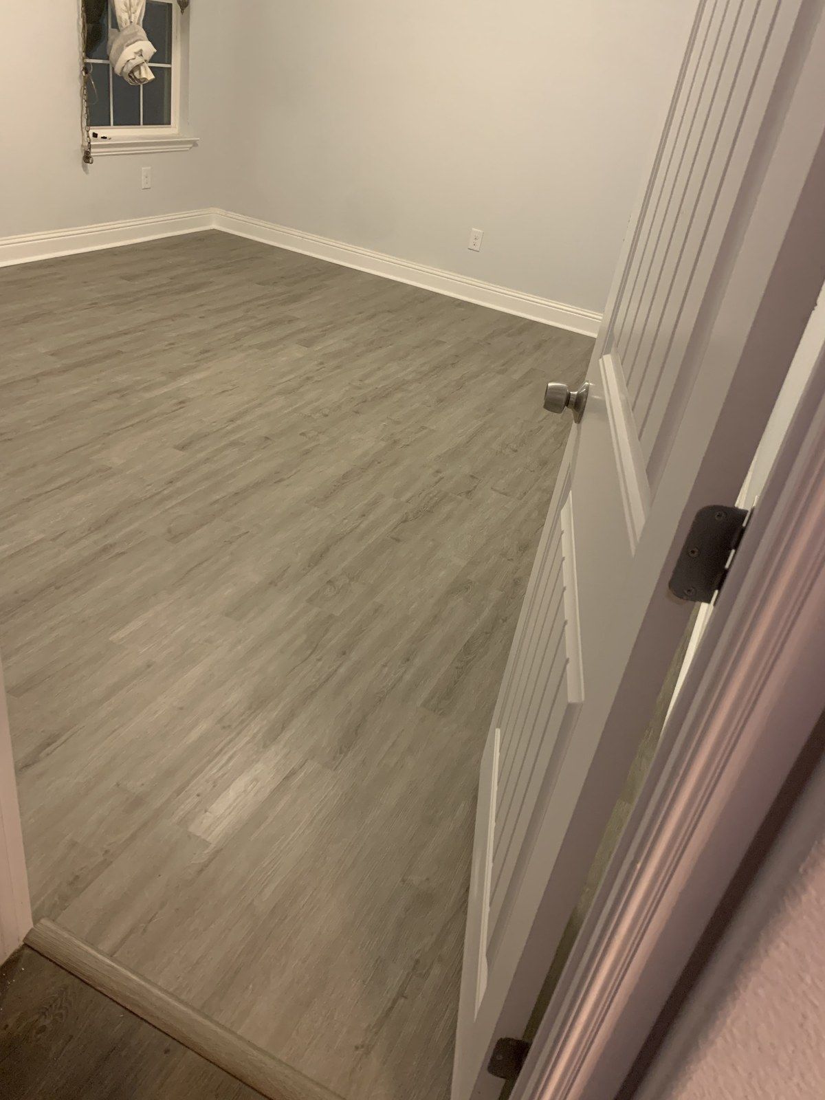 Bedroom with newly installed grey luxury vinyl plank flooring